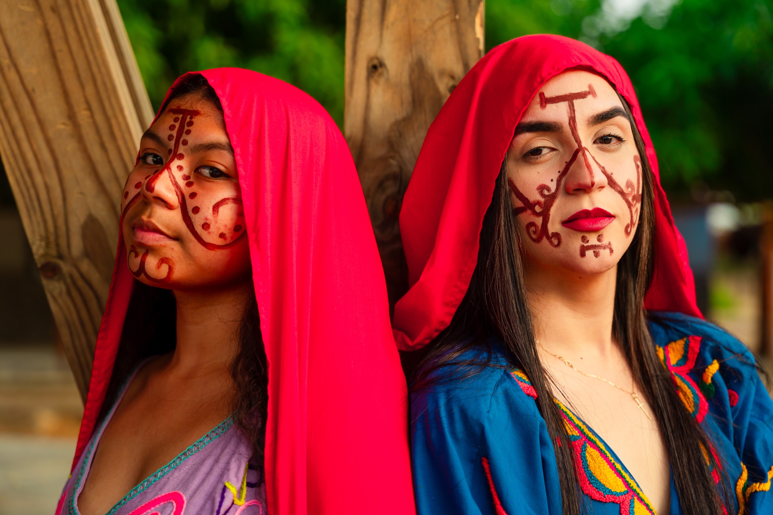 Dos mujeres wayuu con mantas rojas y pintura facial tradicional en La Guajira